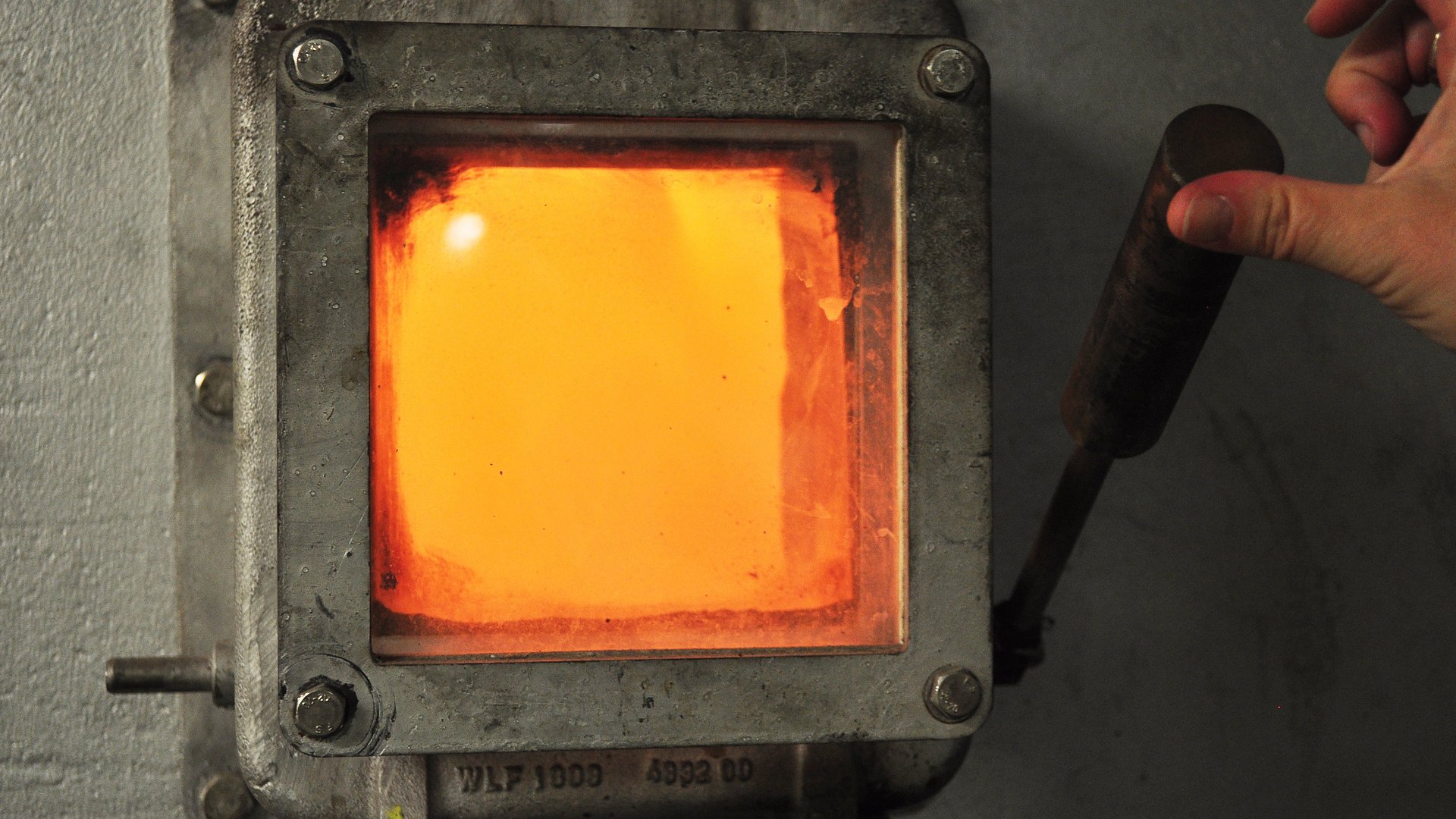 Blick auf eine Glasscheibe, hinter der ein Feuer lodert