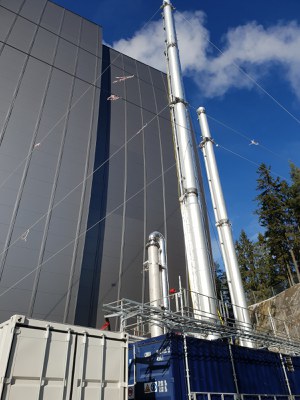 Schornsteine einer Fabrik vor blauem Himmel.